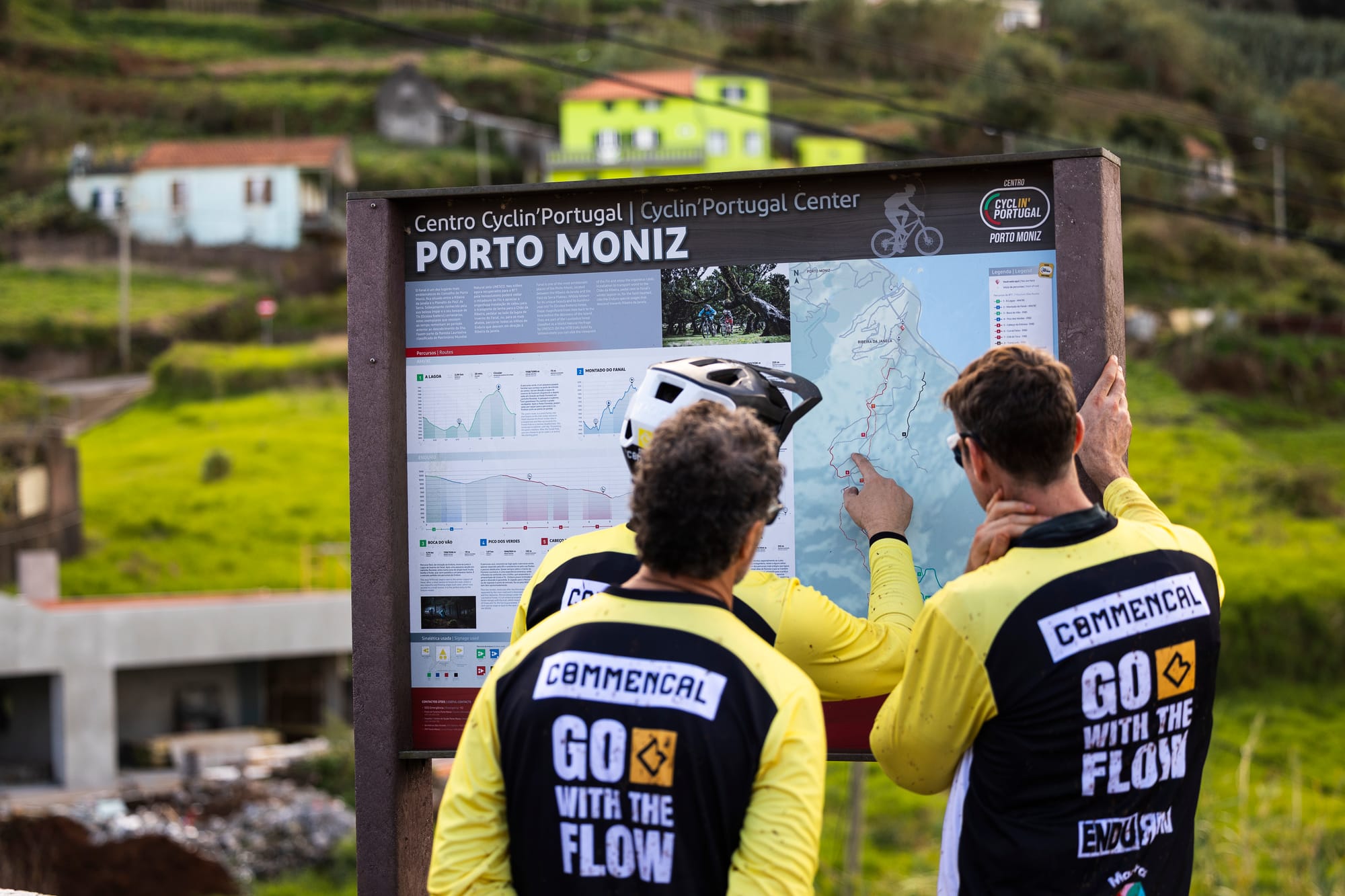 Two riders in Commençal jerseys studying the trail map at the Porto Moniz Cyclin' Portugal Center